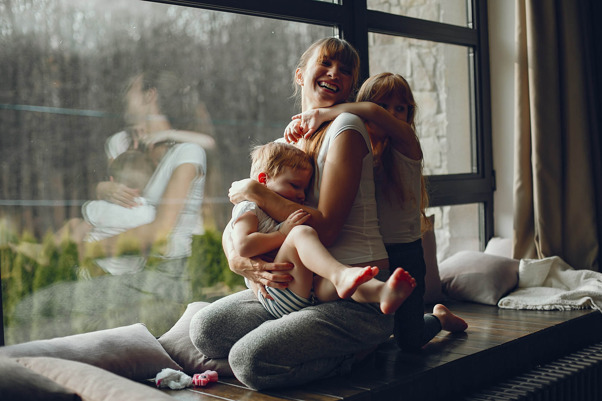Mãe fazendo brincadeiras com crianças em casa em dia de chuva
